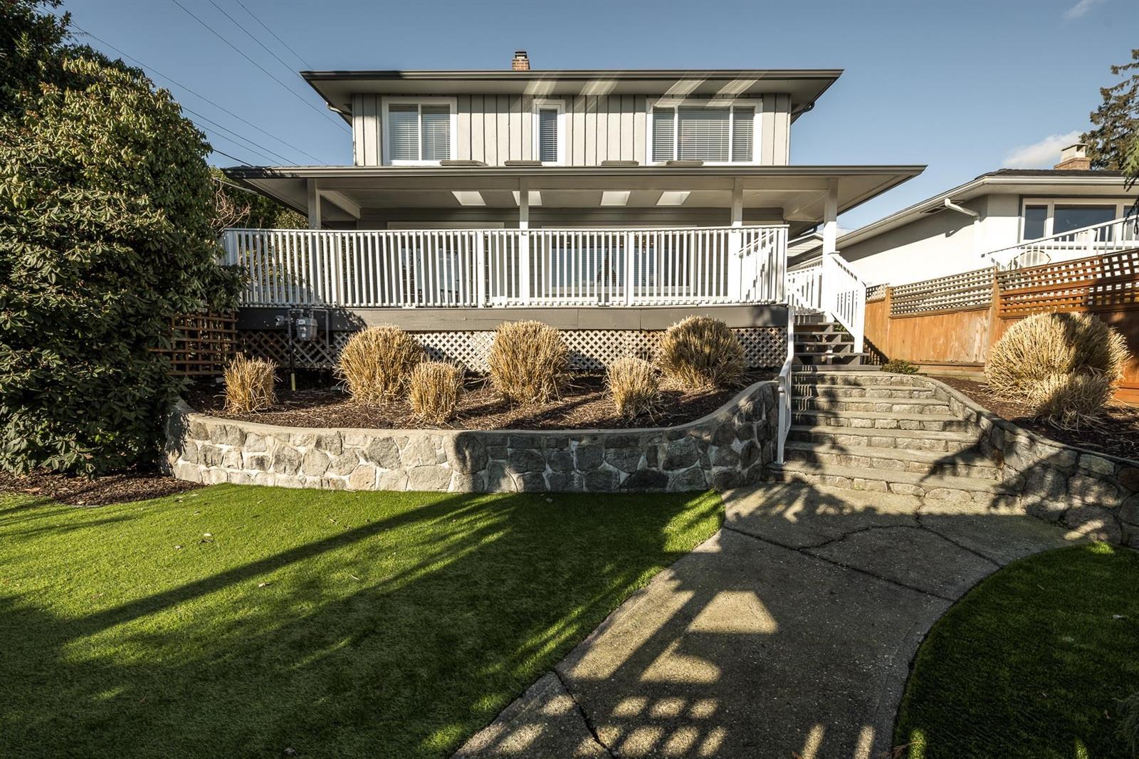The house from Adderley Street, the lawn dropping to a stone wall.
