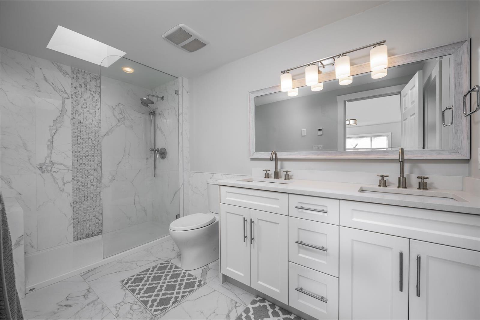 The bathroom off the principal bedroom, a double vanity under a skylight.