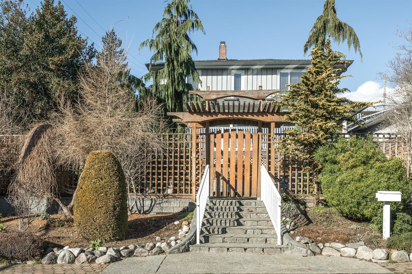 The front approach, a gate under an arbour and steps up through the garden.