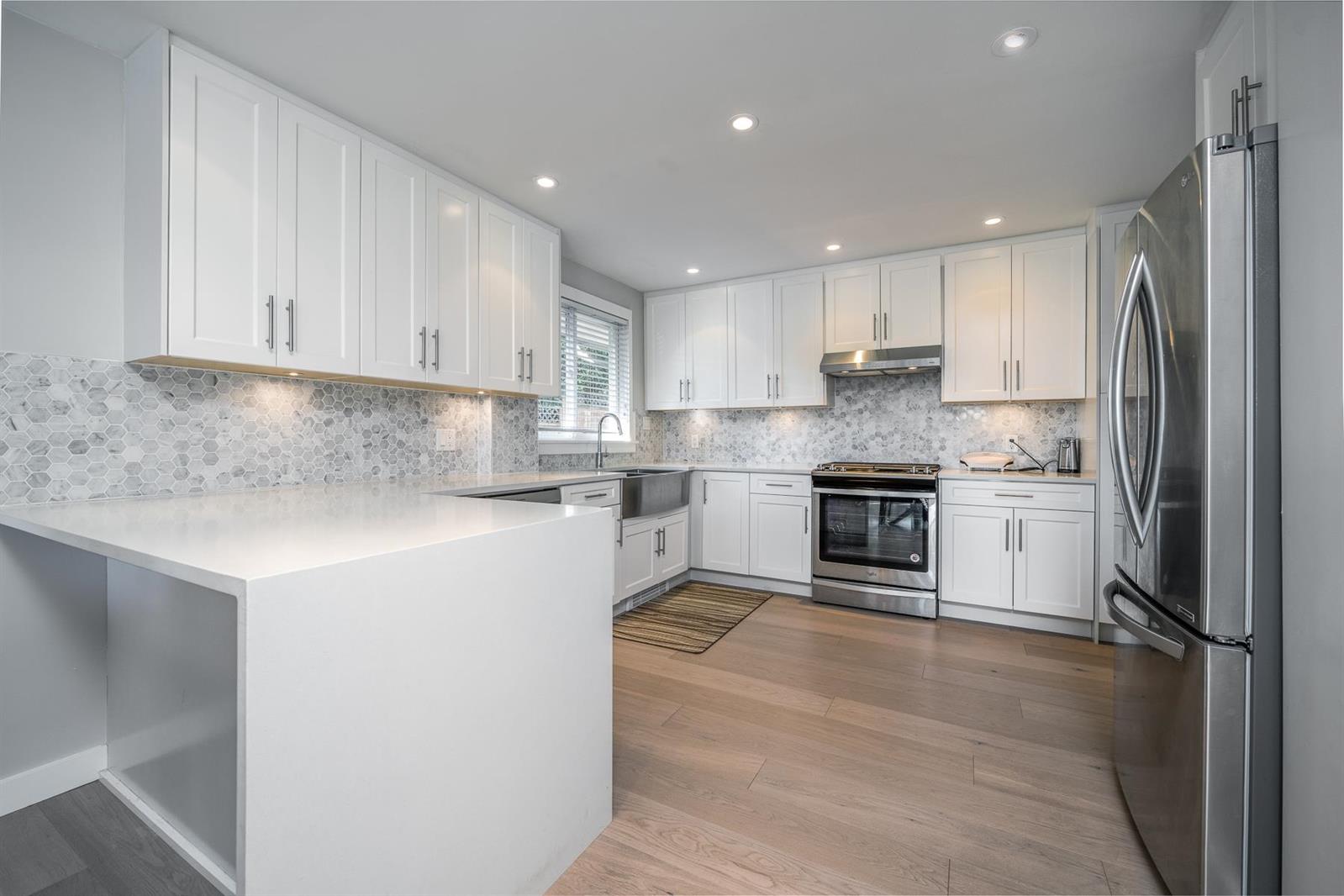 The kitchen, white cabinets and a long island.