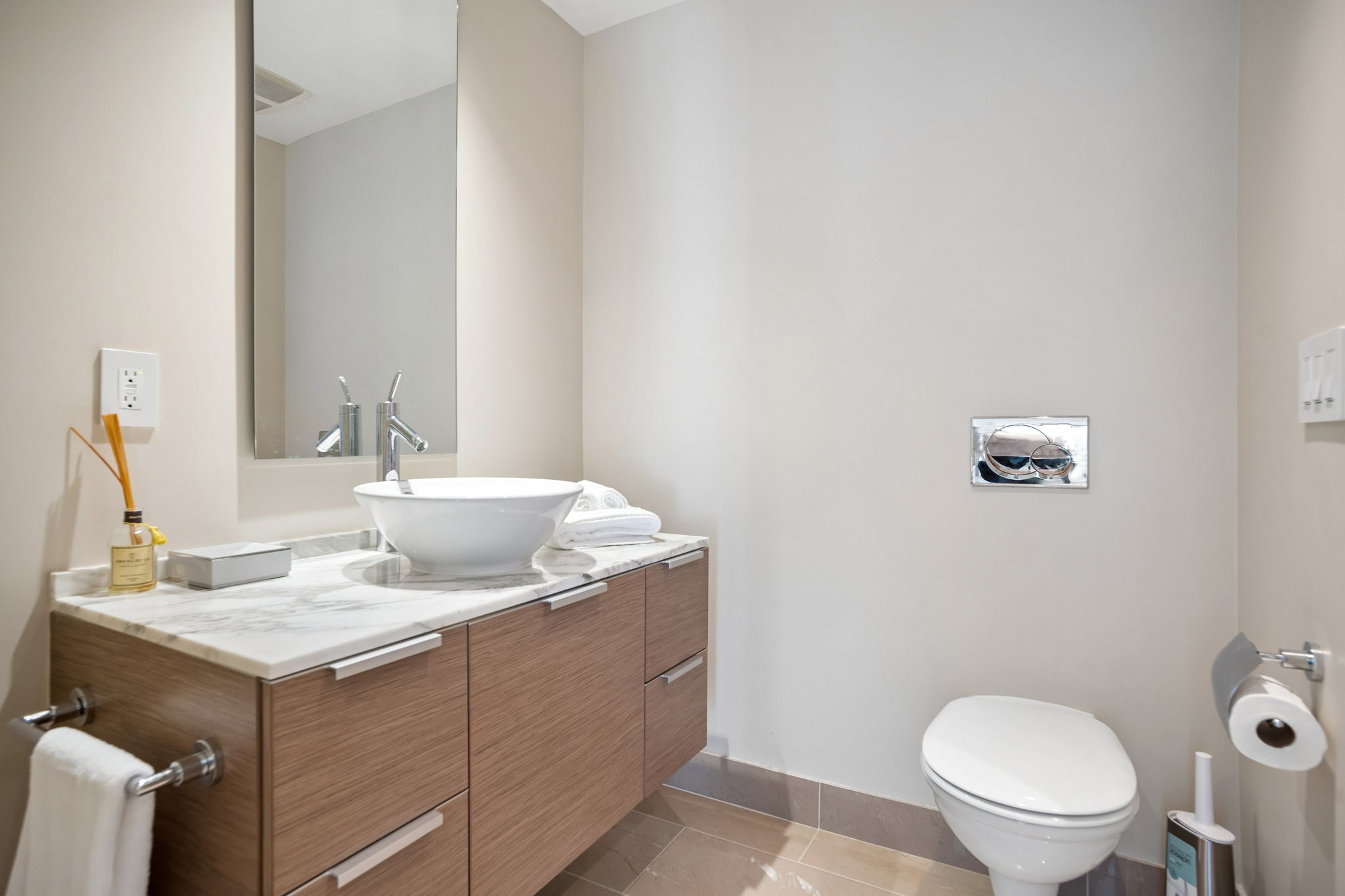 The bathroom, with a vessel basin on a marble-topped oak vanity.