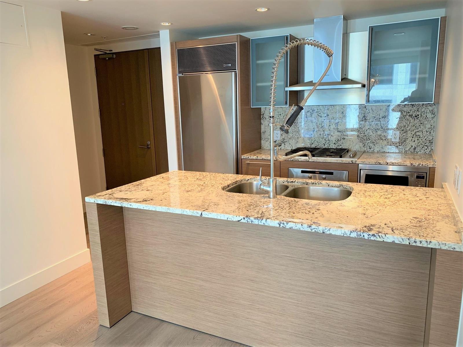 The kitchen from the entry, granite counters running the length of the island.