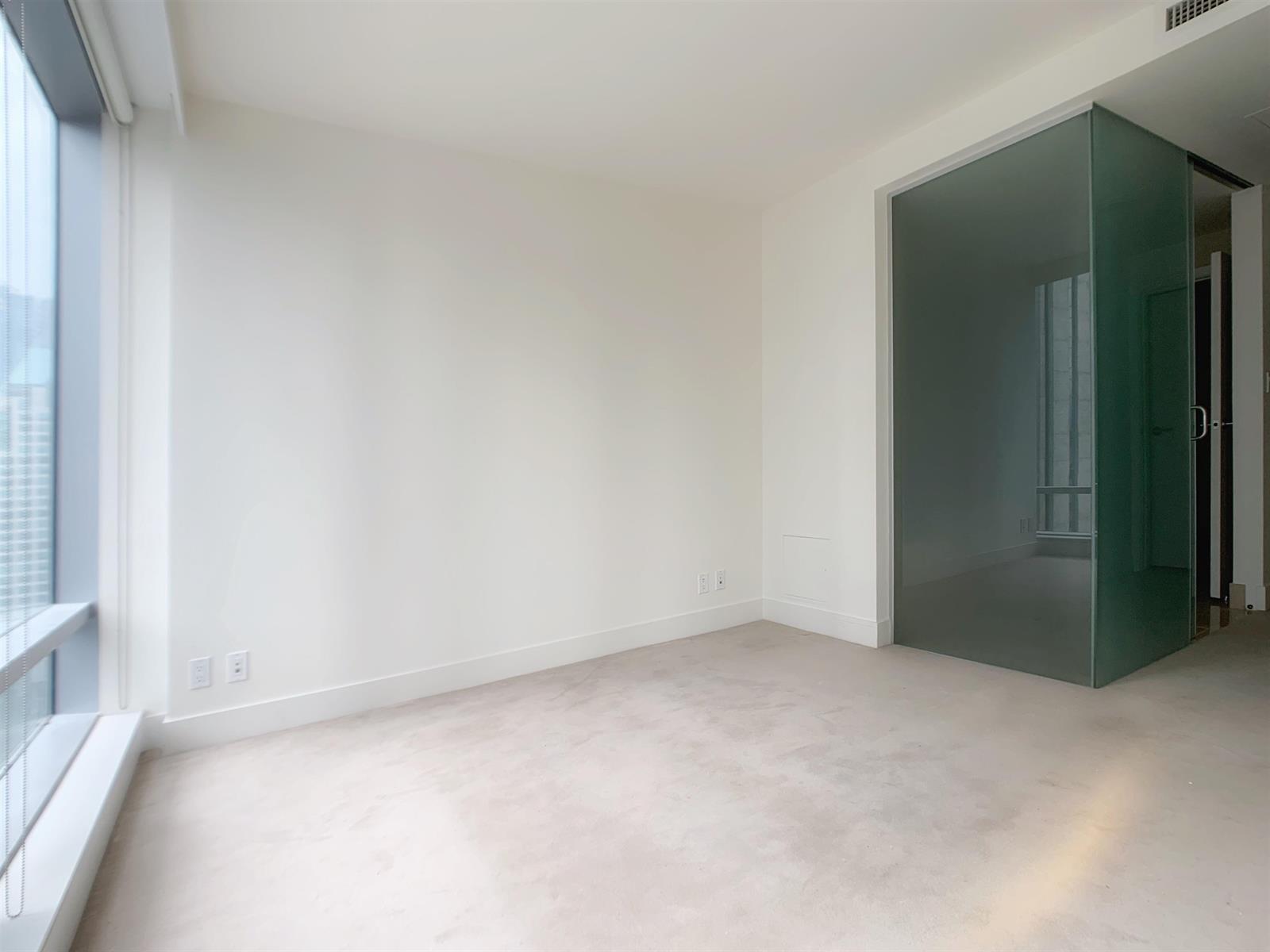 The bedroom from the window, the doorway through to the bathroom at the far end.