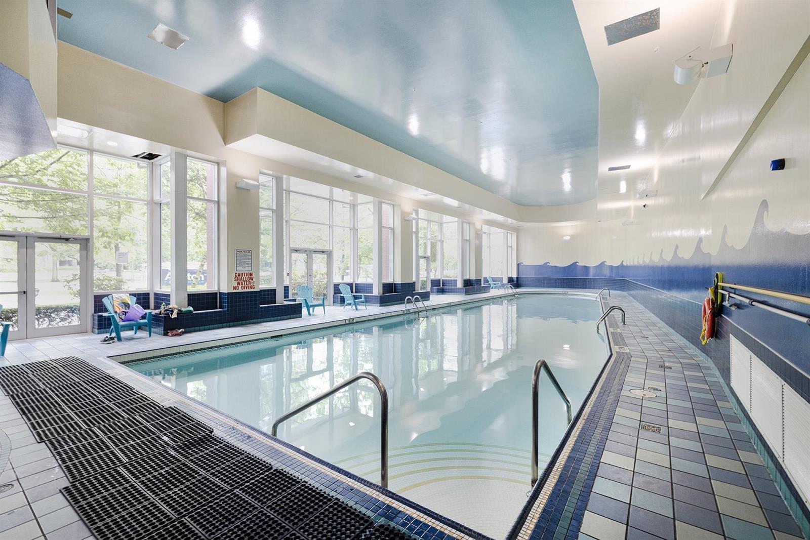 The building's indoor pool, lit along one side by a wall of windows.