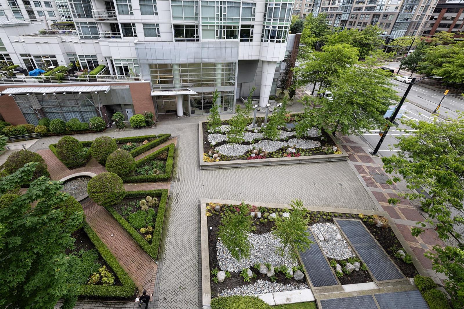 The planted courtyard between the buildings, with clipped hedges and paved paths.