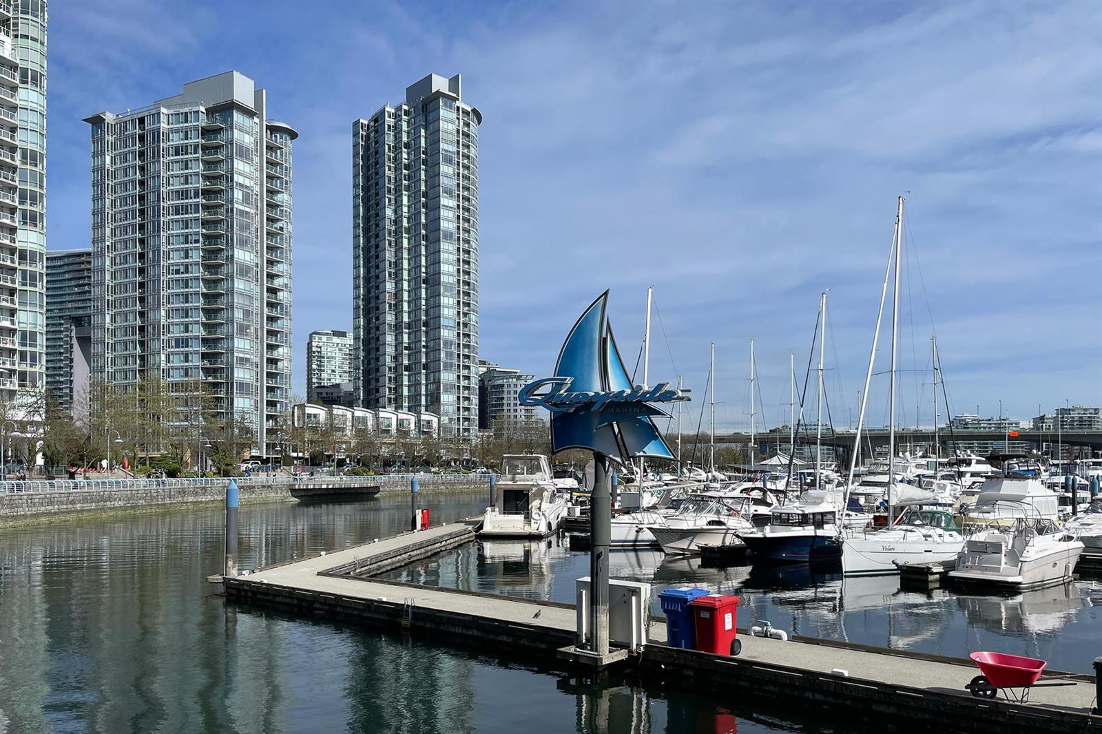 The marina below the building, sailboats along the docks with the Yaletown towers behind them.