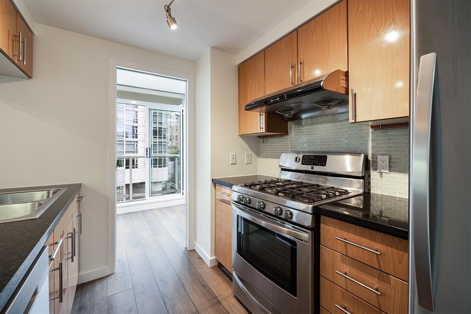 The kitchen from the far end, the range and refrigerator together and daylight over the counter.
