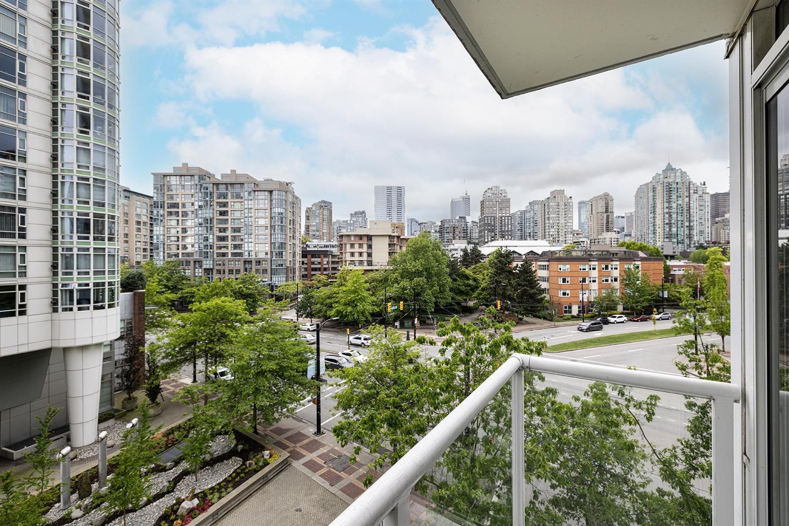 Looking out from the balcony over the treed park and the buildings around it.