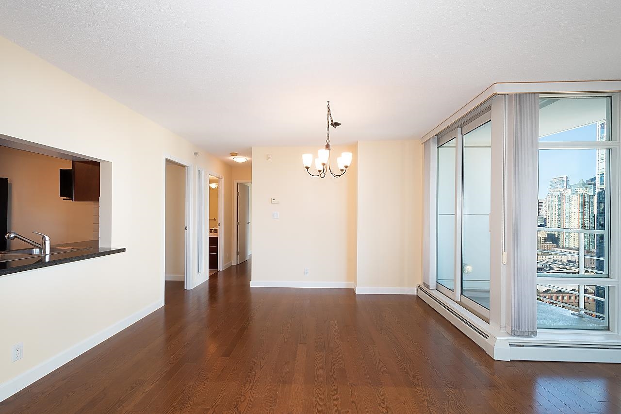 The dining area, the kitchen counter along one side and the glazed balcony at the other.