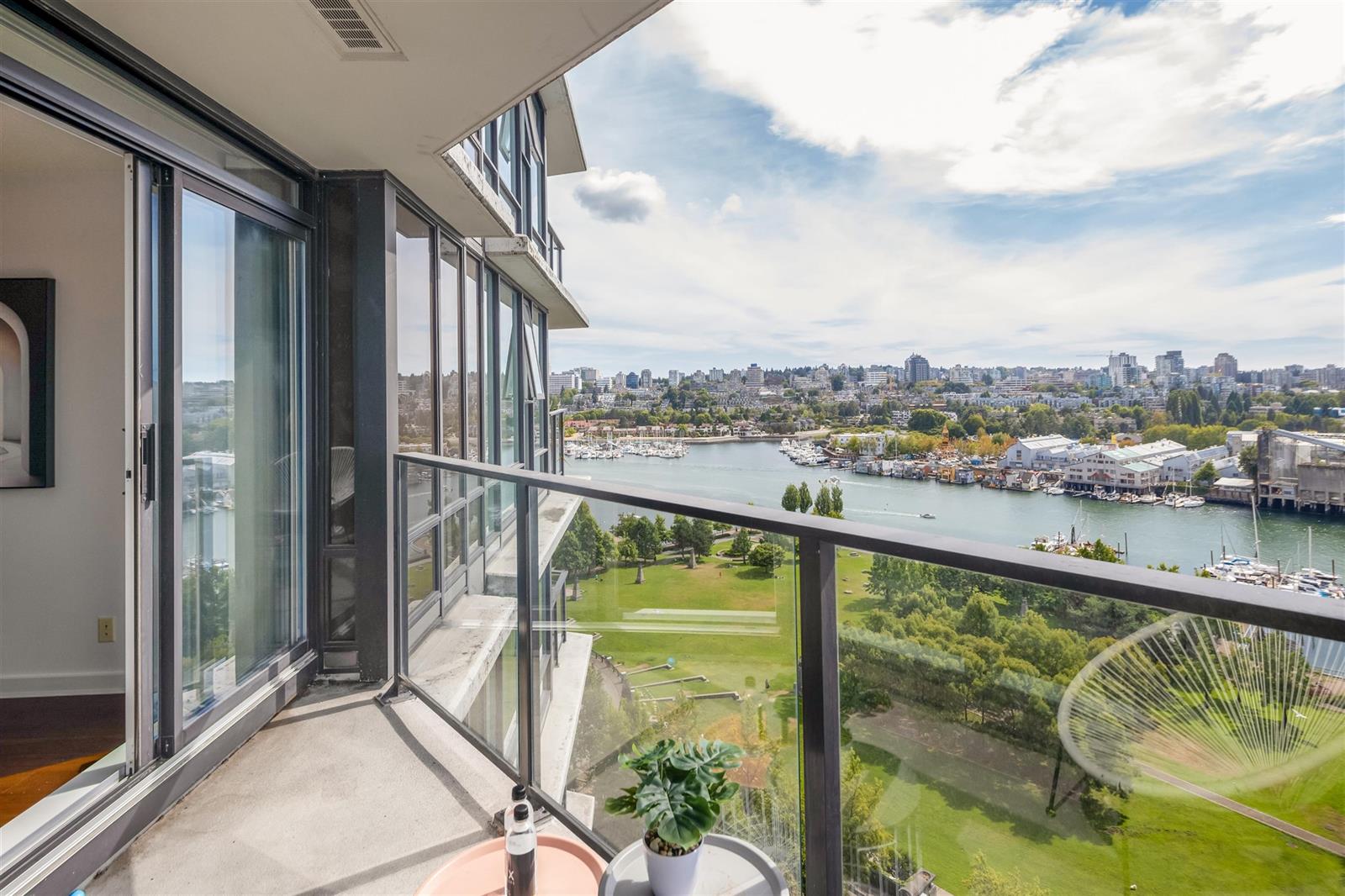The balcony through the glass door, the park and the water stretching away.