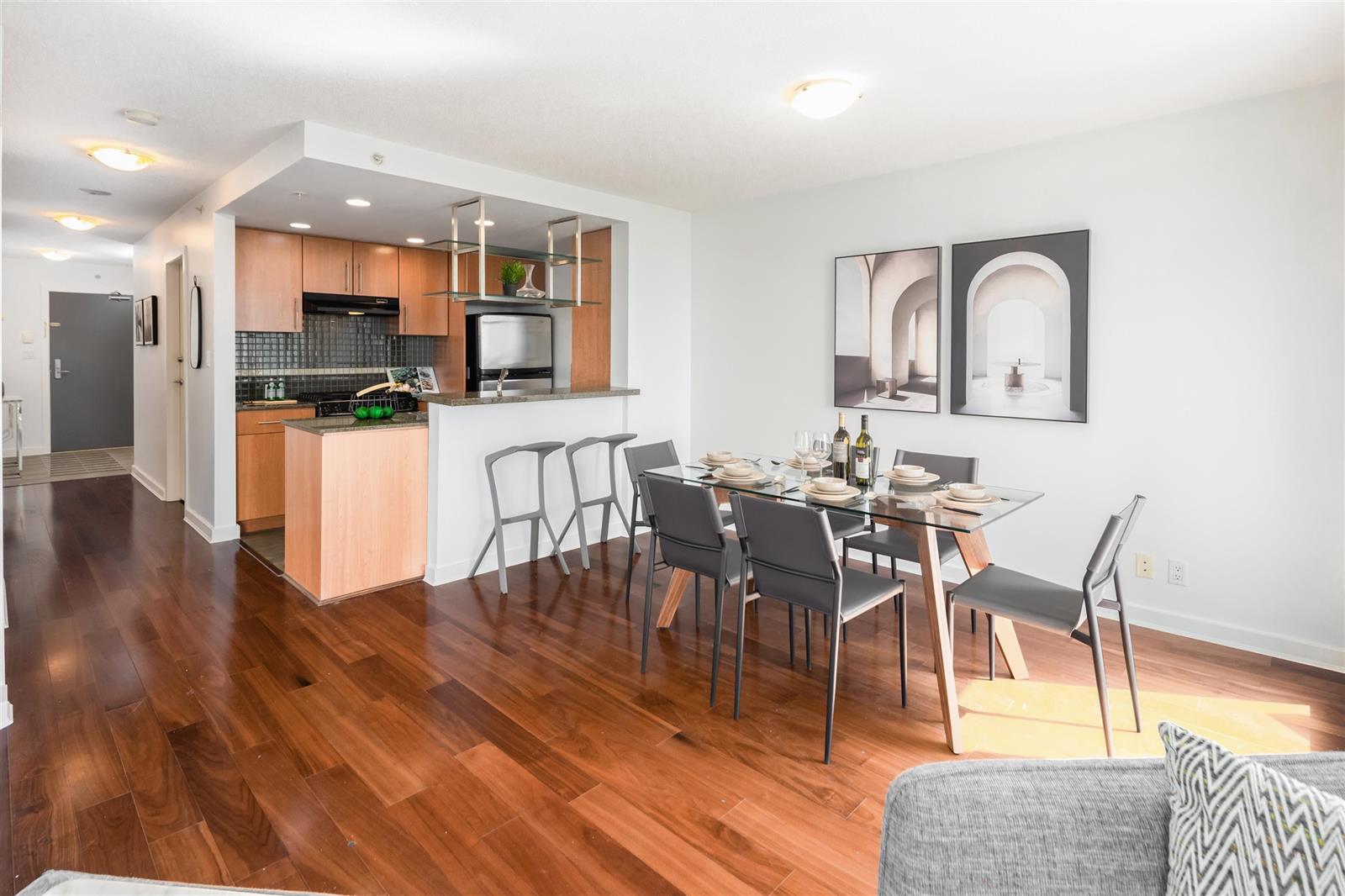 The kitchen and dining room from the living room, timber cabinets running the length of the wall.