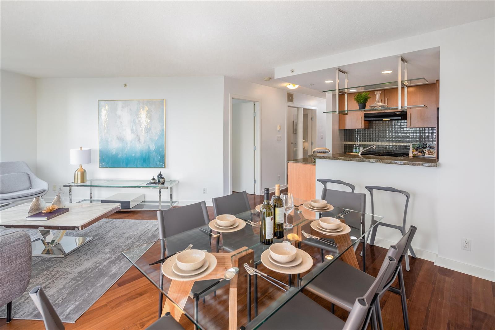 The dining table laid, the kitchen bar and cabinets behind it.