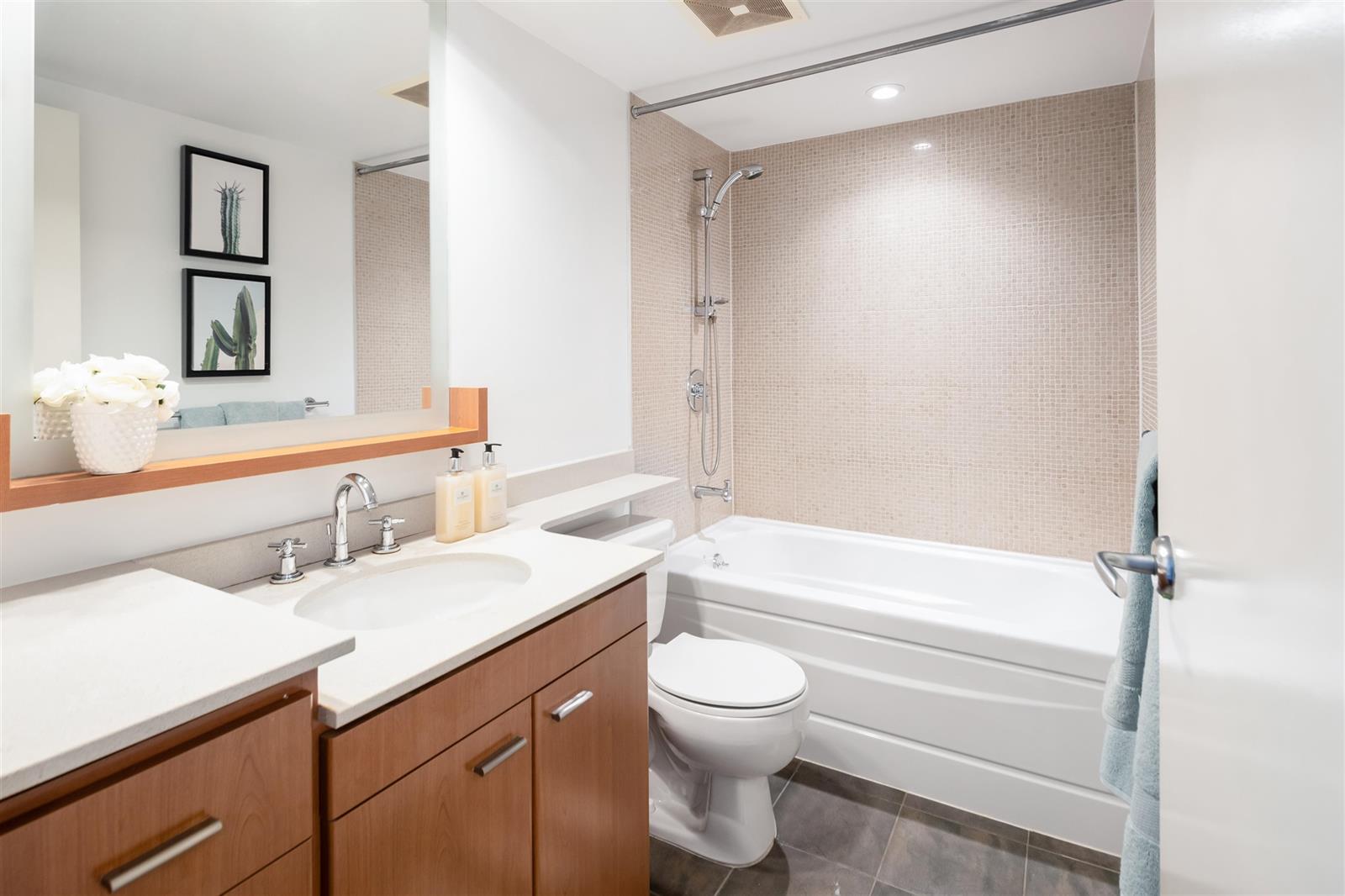 The second bathroom, a tub along the wall beside the vanity.