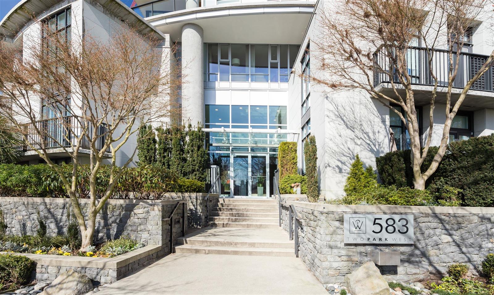 The entrance at 583, steps up between planted beds to the glass doors.