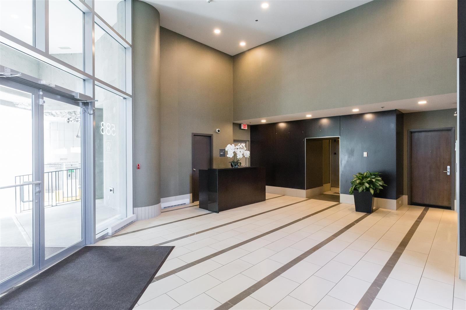 The lobby, a long room in dark panelling with the doors at the far end.