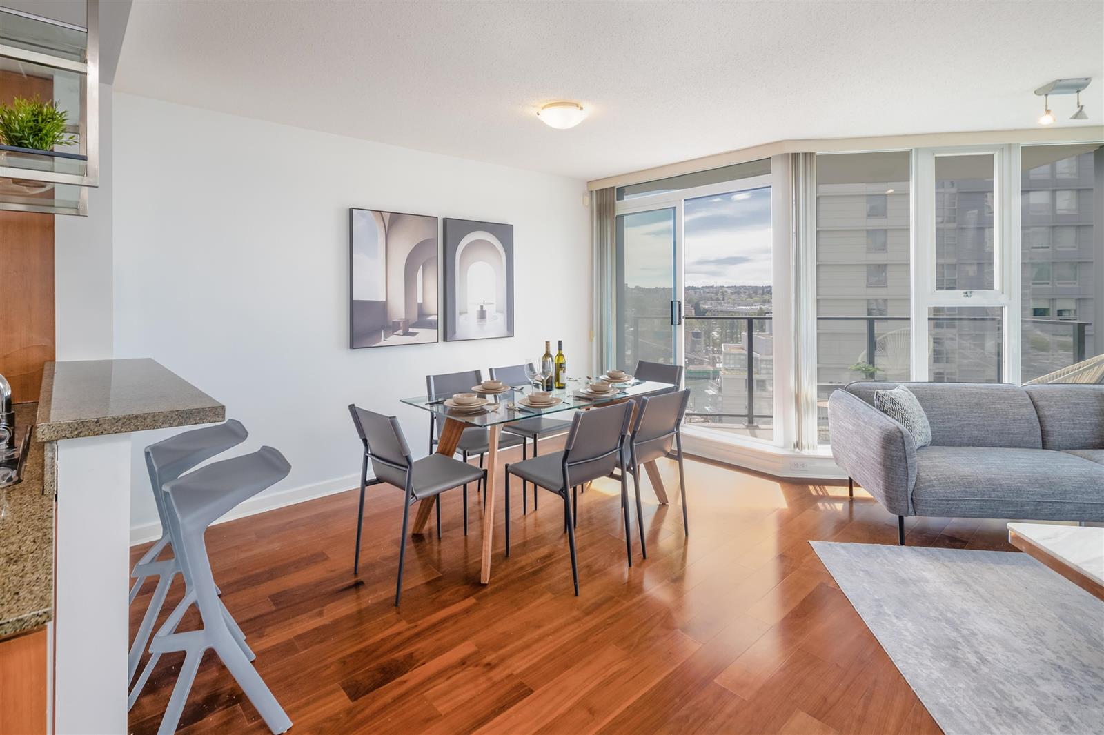 The dining table by the balcony door, the living room opening out beyond it.