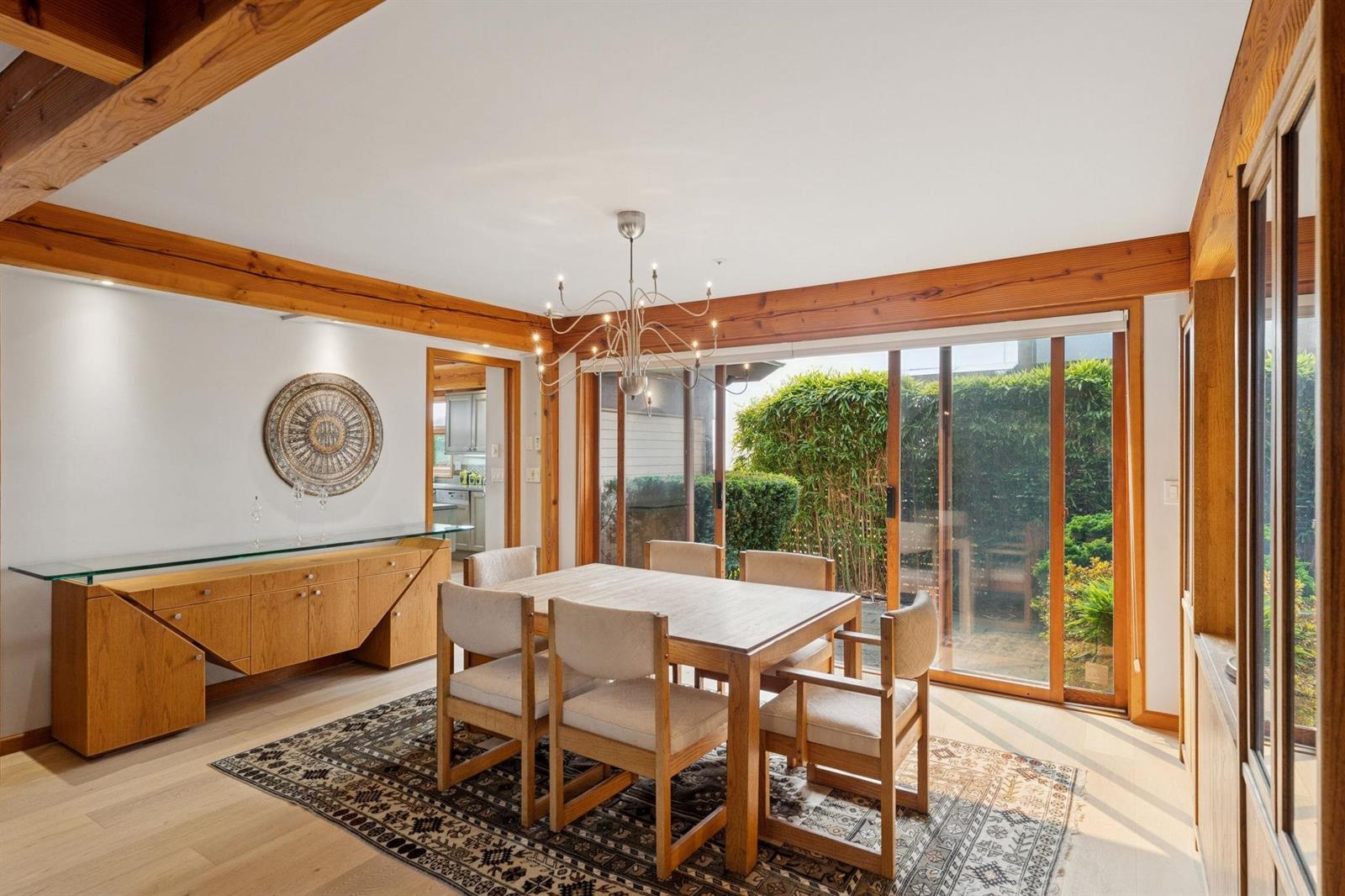 The dining room with a platter on the sideboard and light coming in from two sides.