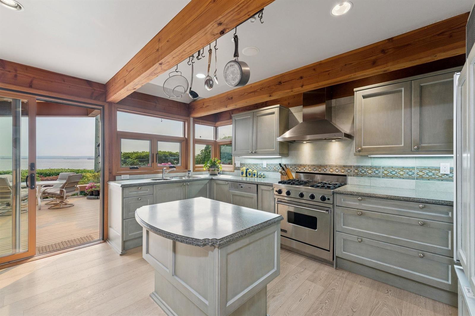 The kitchen island with the range behind it and the ocean out the window.