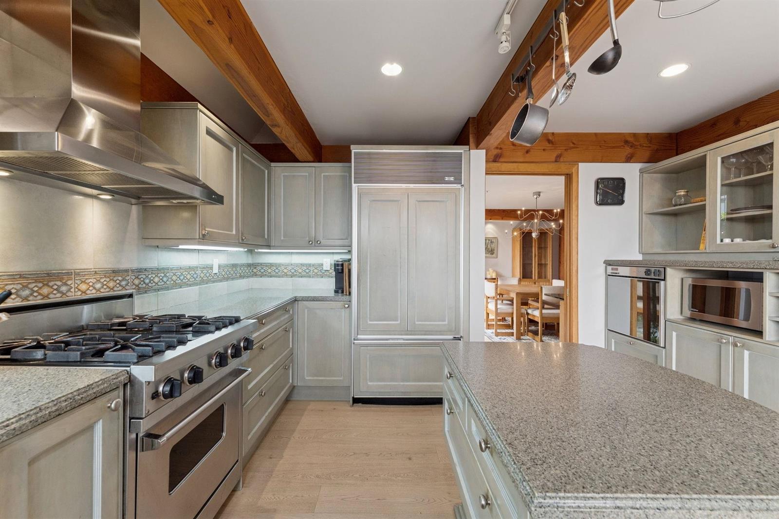 The kitchen looking toward the range and the tall refrigerator.