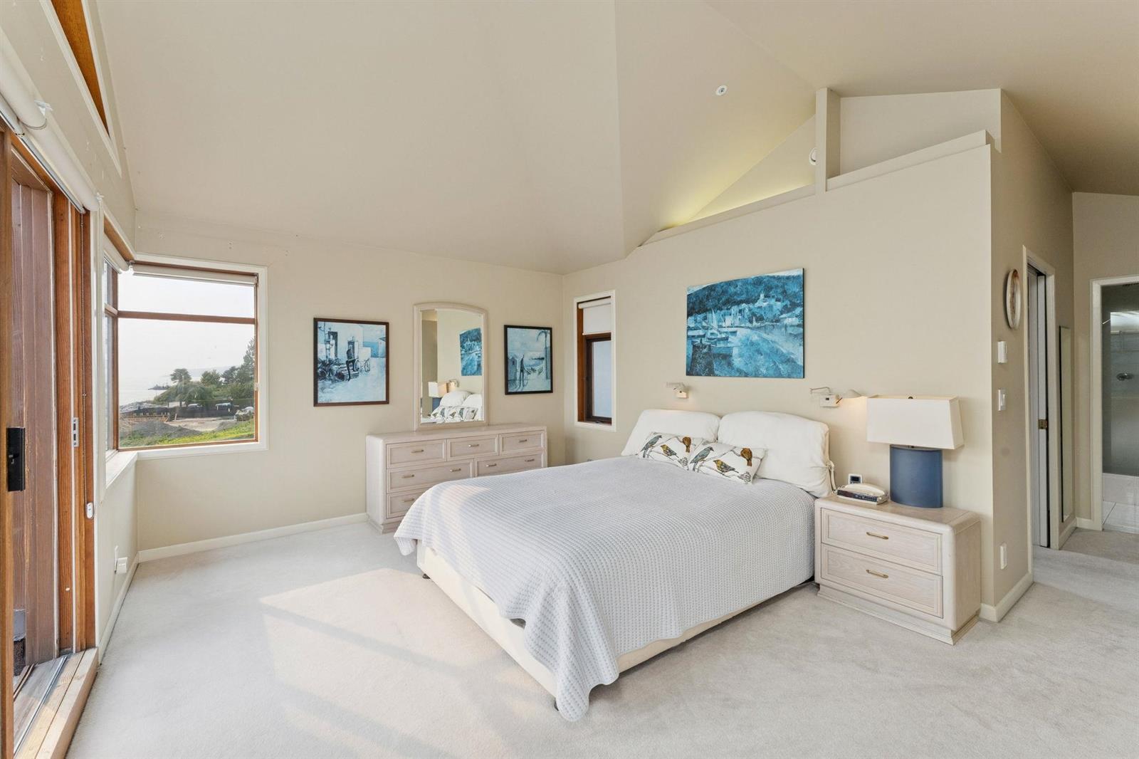 The primary bedroom from the door, artwork above the bed and light from the skylight.