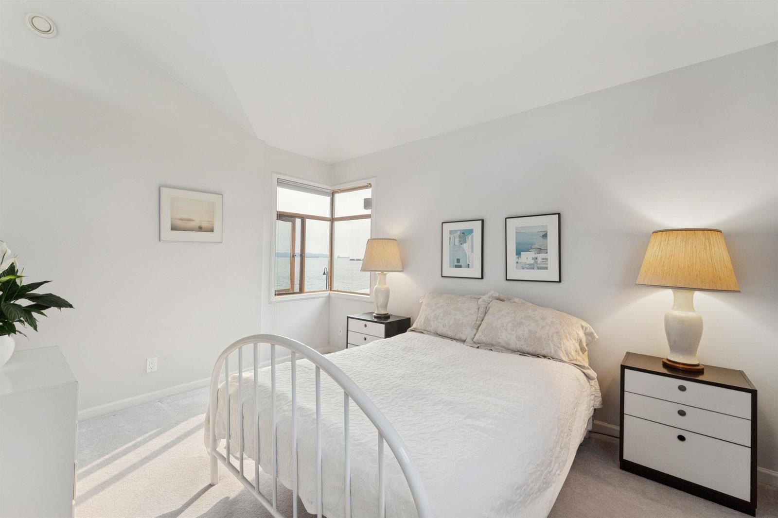 A second bedroom, an iron bedstead between two lamps.