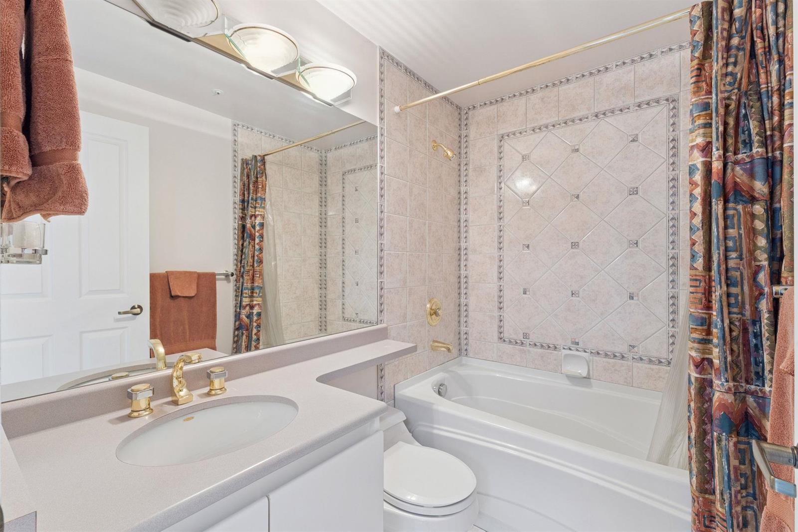 A second bathroom, a tub under a curtained window.