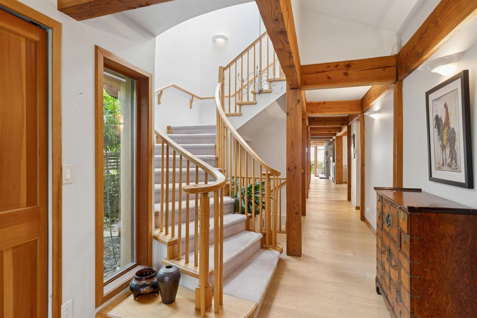 The curved staircase in the entry hall, pale wood balustrade against white walls.