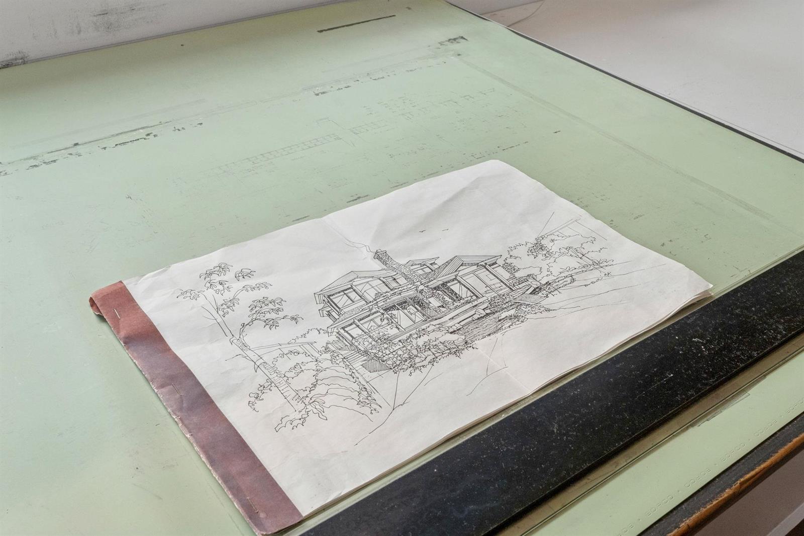 The architect's original drawing of the house, laid out on the drafting table.