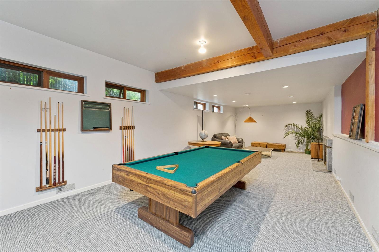 The recreation room with a billiard table under the beams.