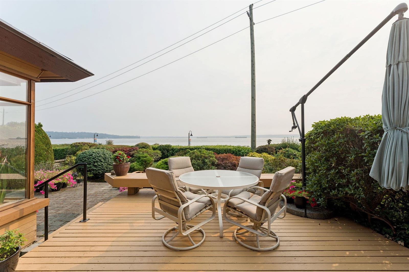 The upper deck, a table and chairs set out with the ocean beyond the rail.