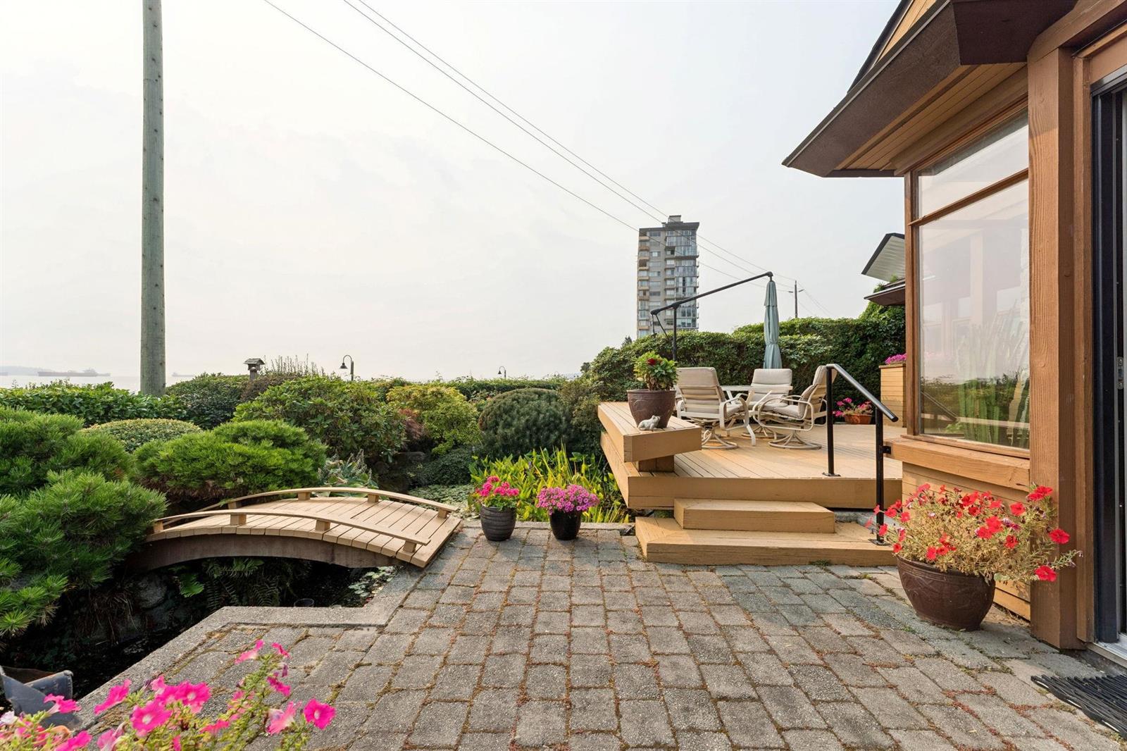 The stone path down through the garden, planters along the way and the water beyond.