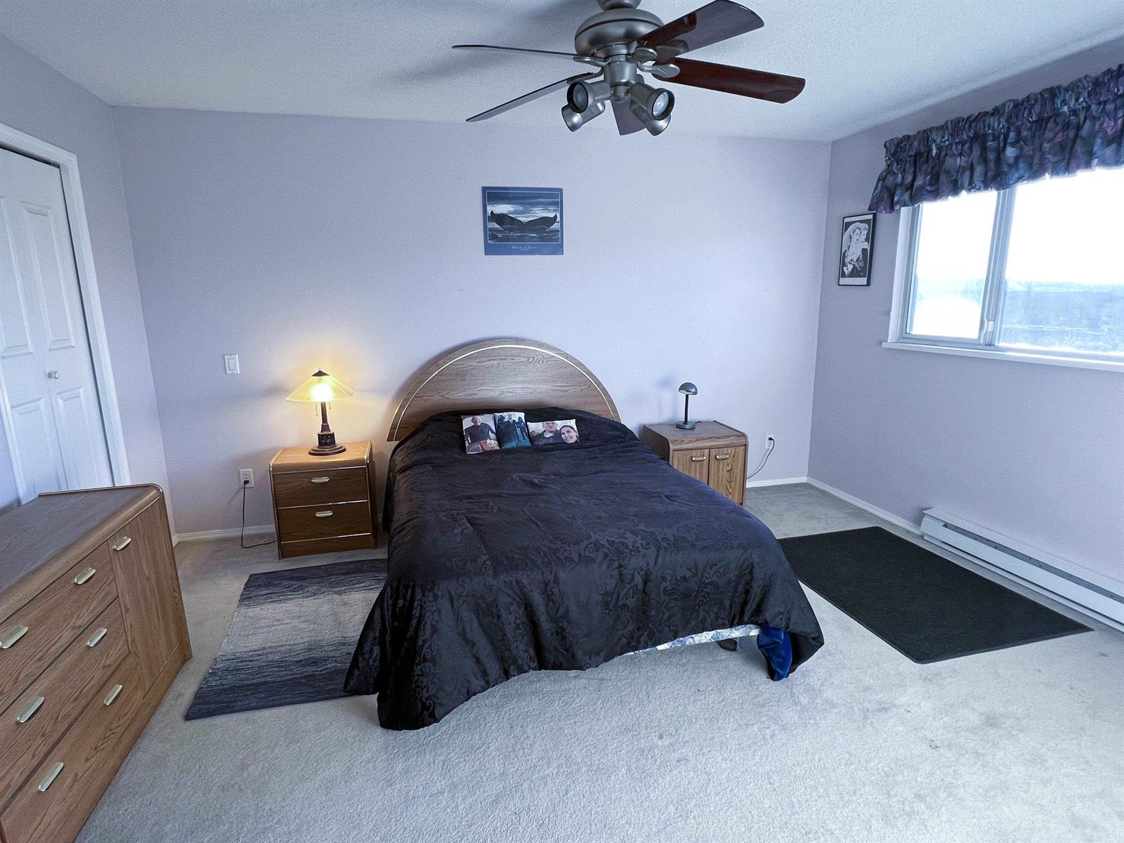 The main bedroom, a bed against the far wall and a window to one side.