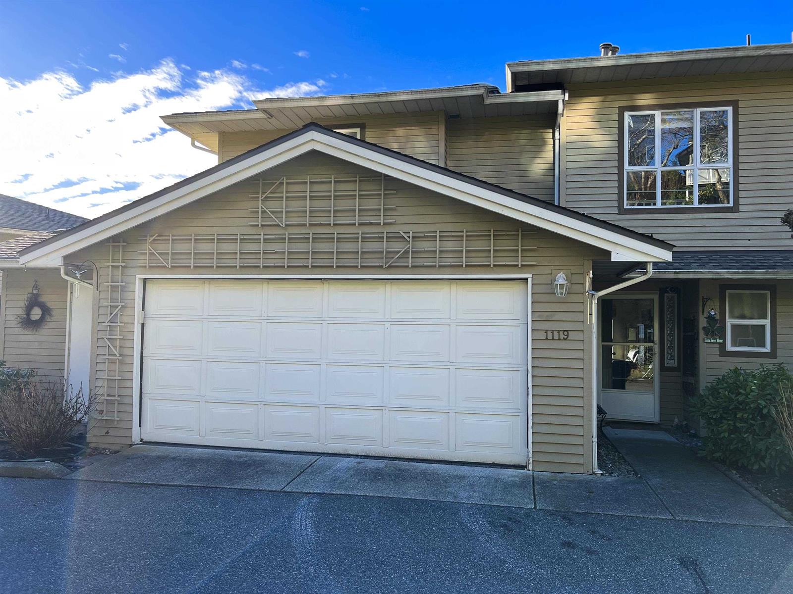 The front of the townhouse, a double garage under the upper storeys with the entry to one side.