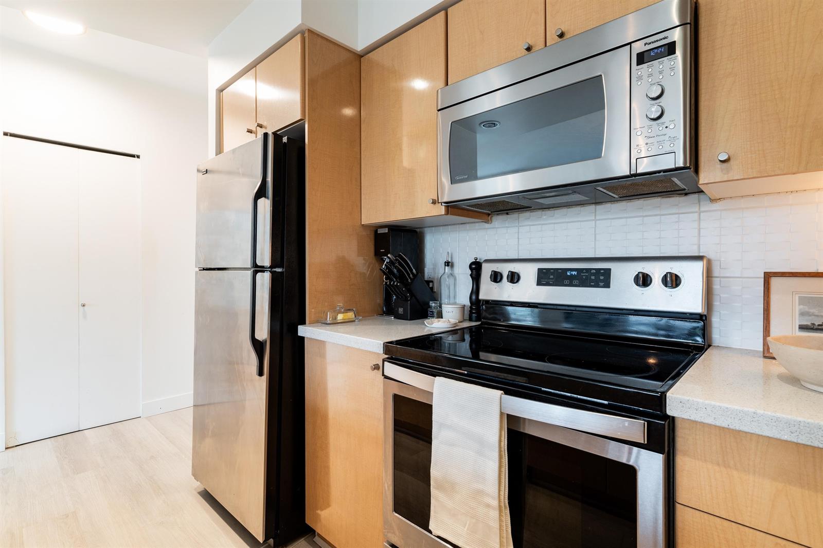 Range, microwave and refrigerator together down one wall of the galley.