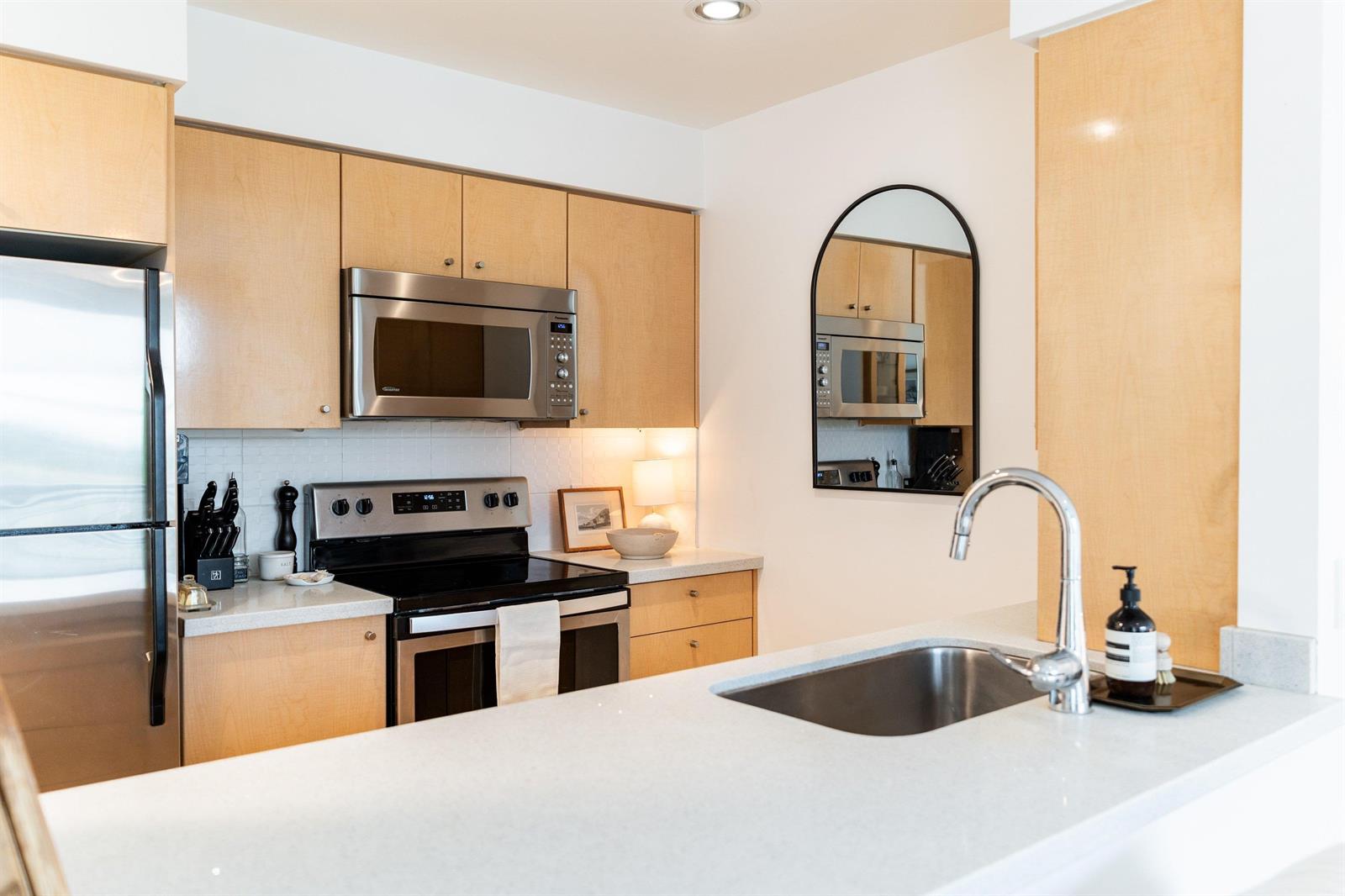 Across the stone peninsula to the range and the arched mirror above the sink.