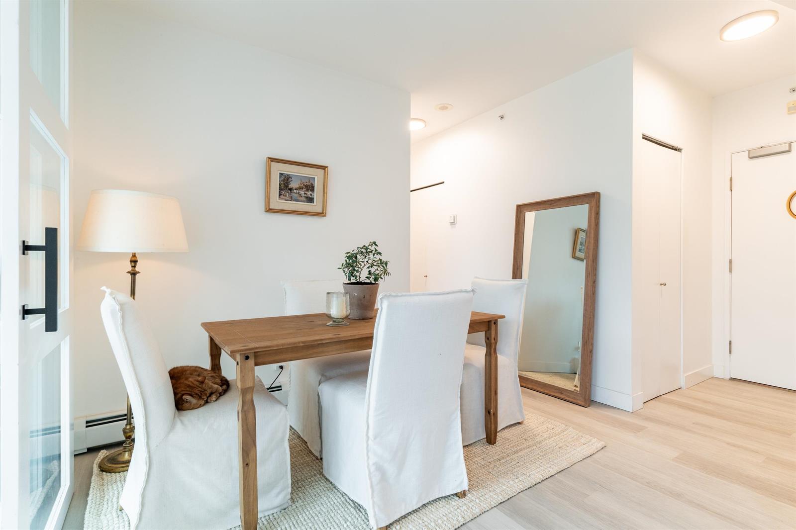 The dining area seen from the living room, the barn door standing open and a framed picture on the wall.