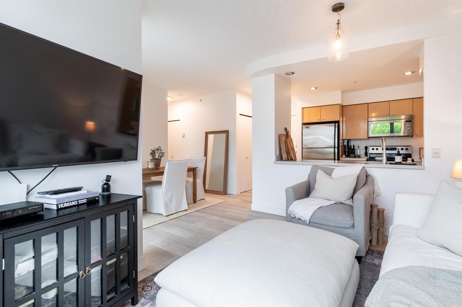 Past the television cabinet into the second bedroom, the bed and a mirror on the wall.