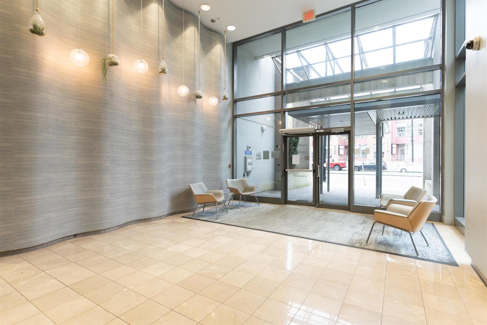 The lobby itself, double height and glazed to the street, with seating along one wall.