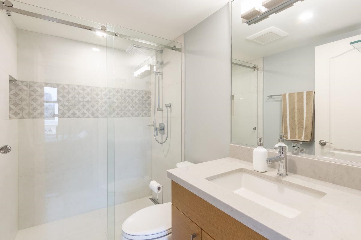 The bathroom off the principal bedroom, a glass shower beside the vanity.