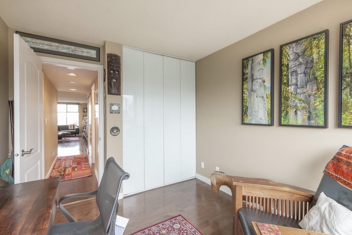 The hall, cupboards along one side and a room beyond.