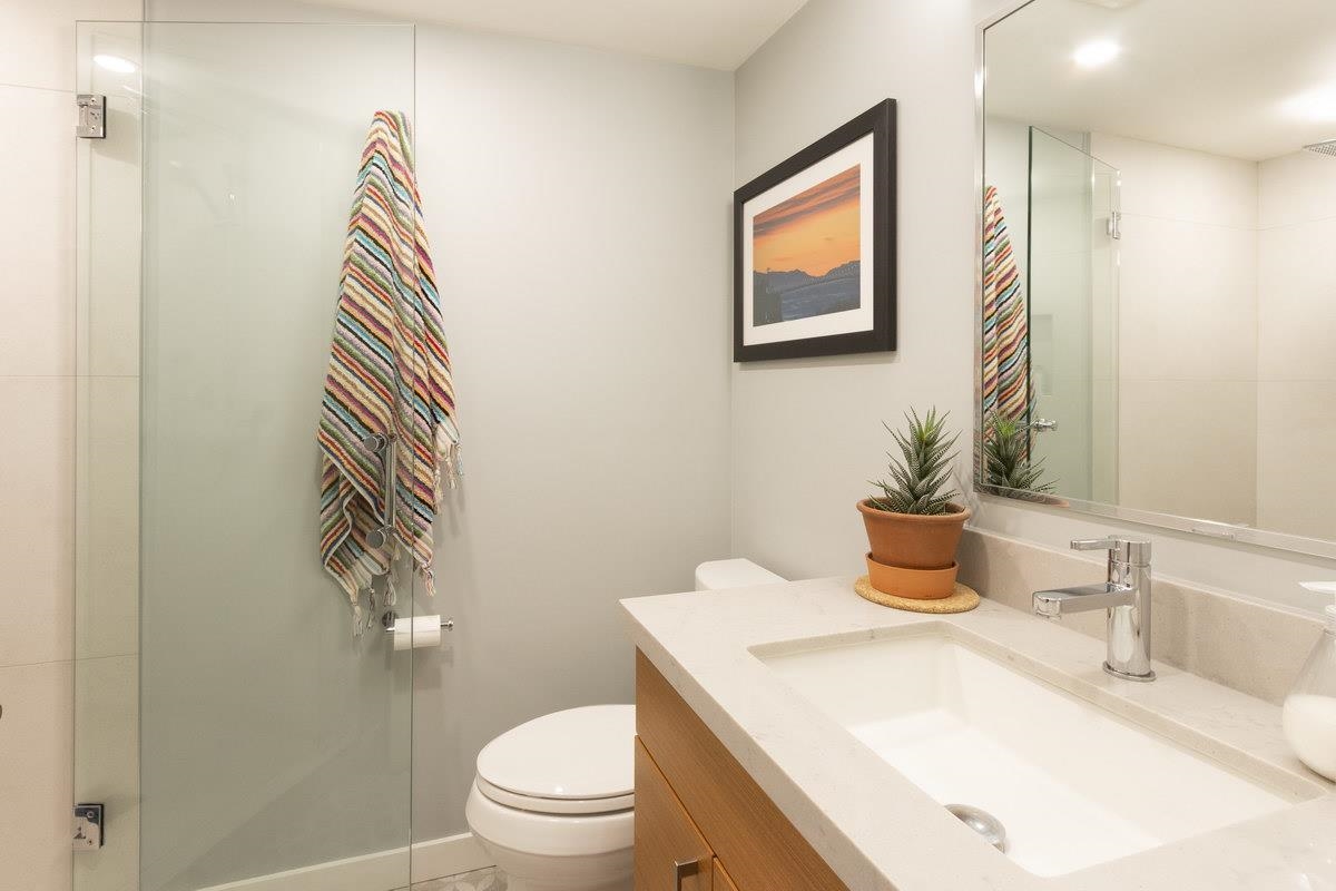 The second bathroom, a glass shower and a long vanity.