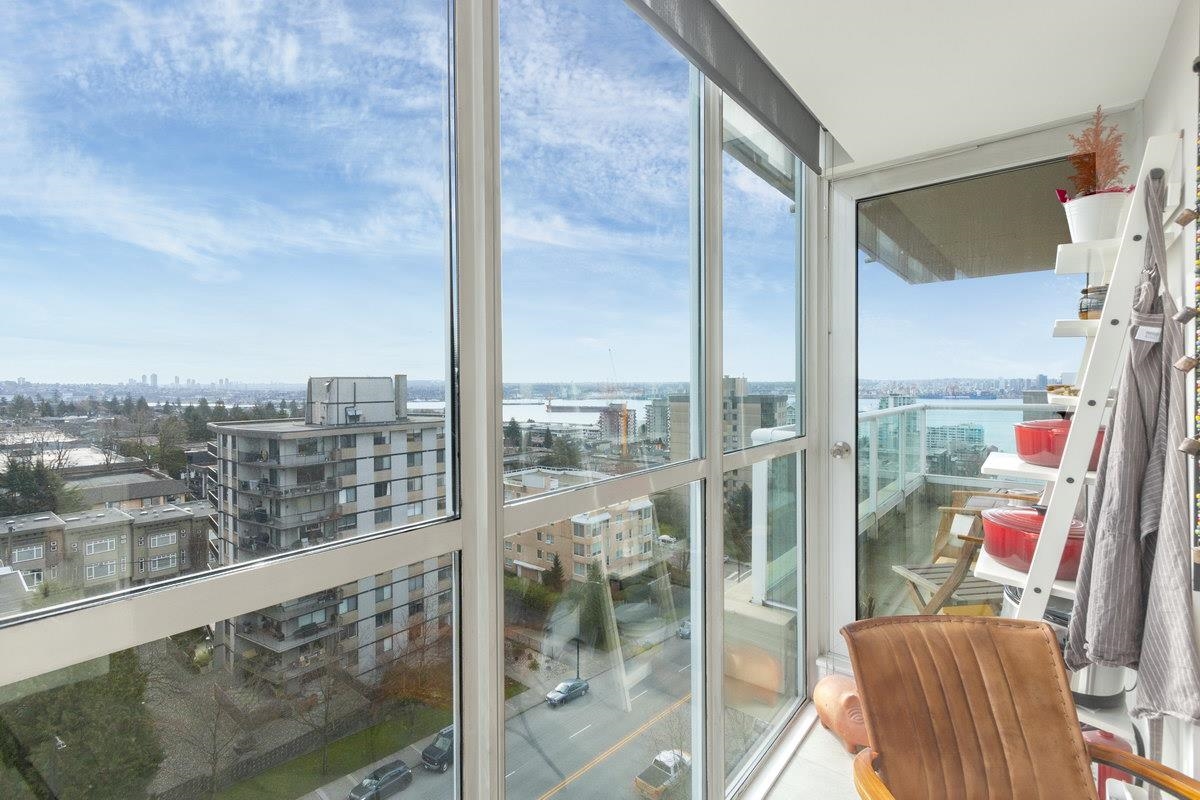The corner of glass in the living room, the balcony rail and the drop to the street below.