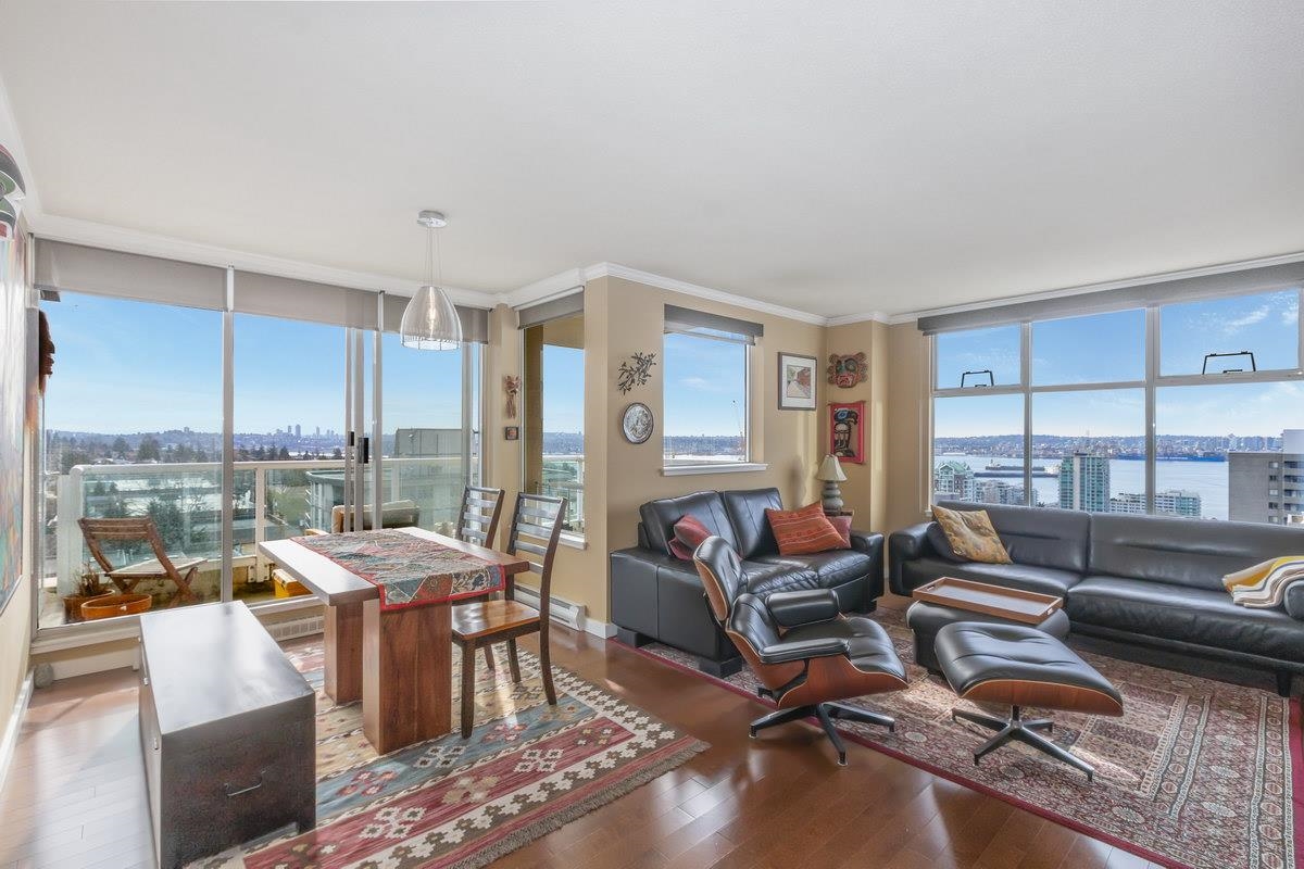 The living room, seating on a patterned rug with the window wall carried around the corner.