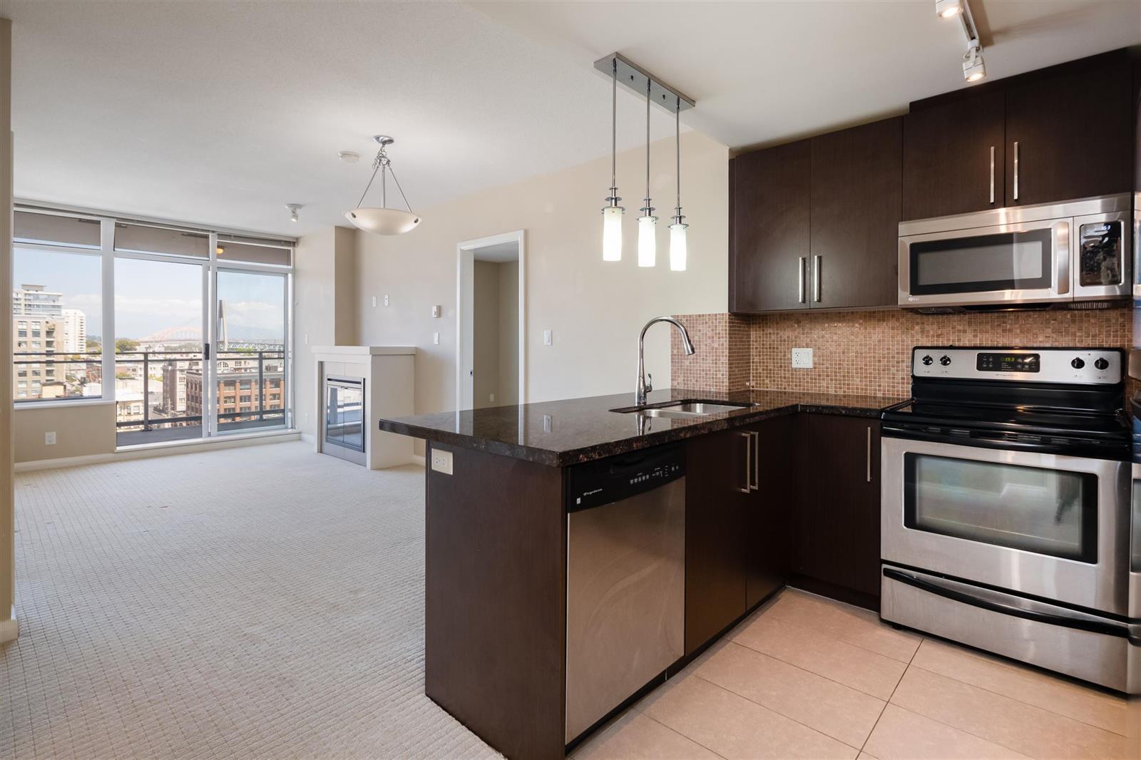 The kitchen with the corner windows behind it, the city visible past the counter.