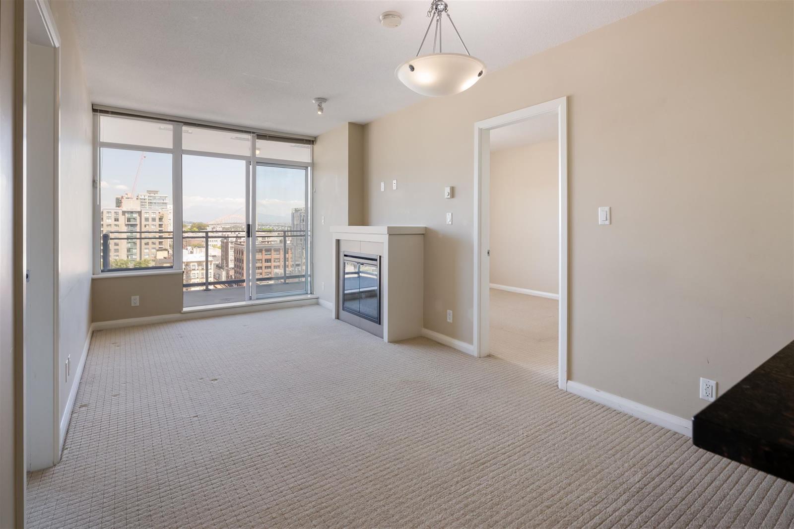 The living room corner, windows running from wall to wall over the city, with the hallway doors alongside.