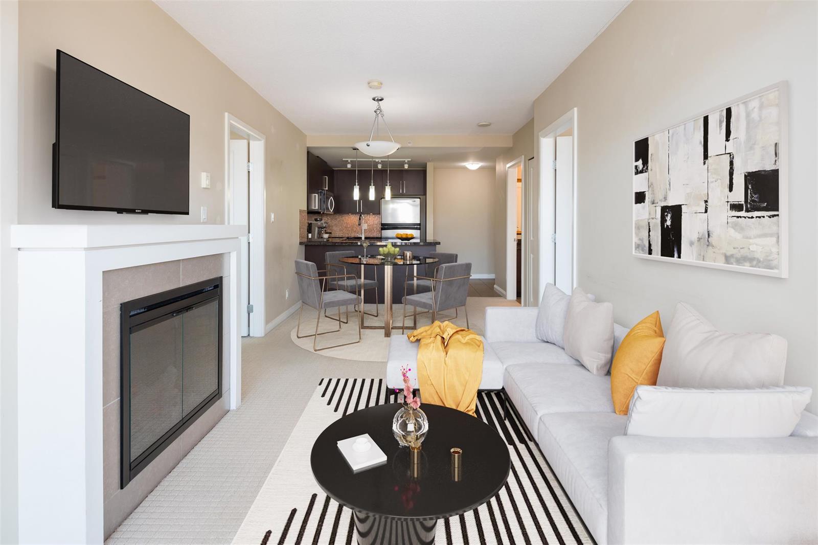 The living room from the entrance, the fireplace and television on the near wall and the dining table and kitchen beyond.