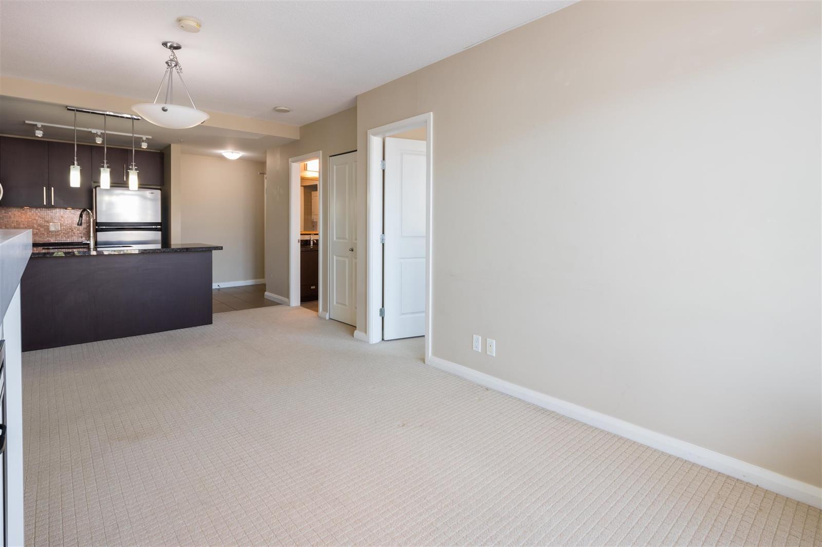 The empty living room looking toward the kitchen, the raised counter dividing the two.