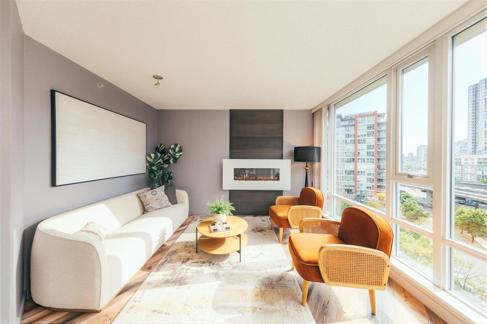 The living room seen from the dining end, sofa and chairs at the fireplace wall.