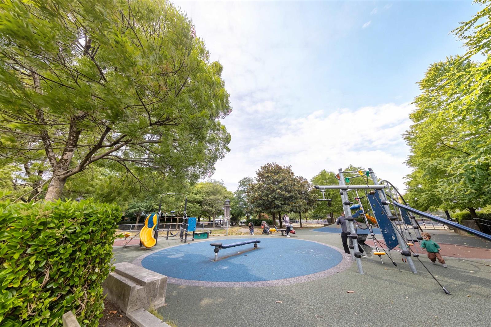 The park across the street, a playground under the trees.