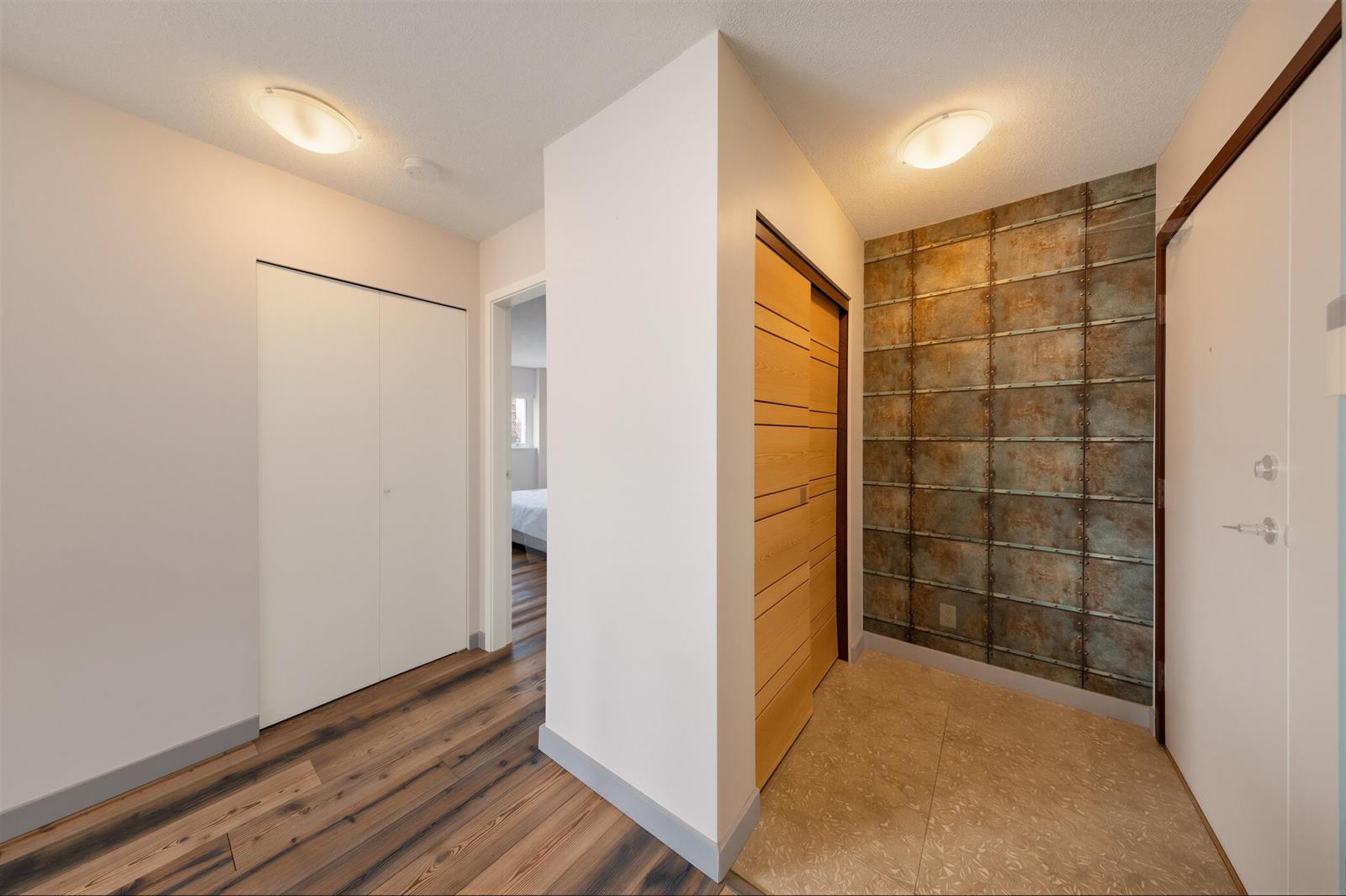 The entrance hall, a panelled door and the closets running back towards the living room.